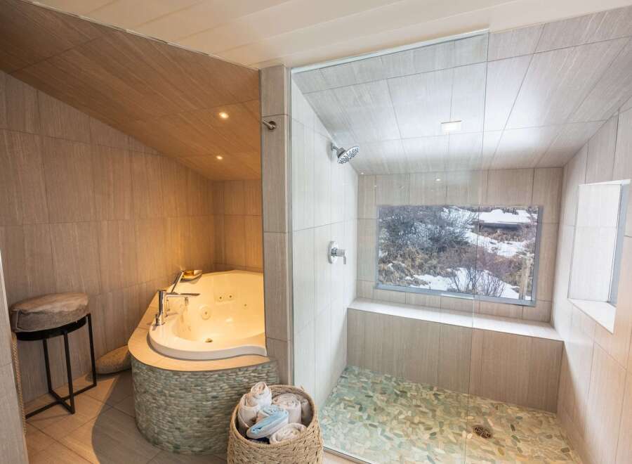 Indulge in luxury with this spa-like bathroom featuring a jacuzzi tub and a separate shower.