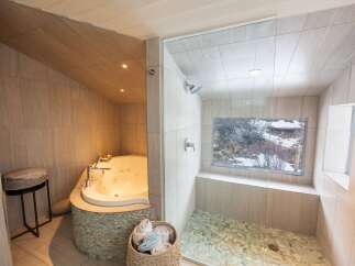 Indulge in luxury with this spa-like bathroom featuring a jacuzzi tub and a separate shower.