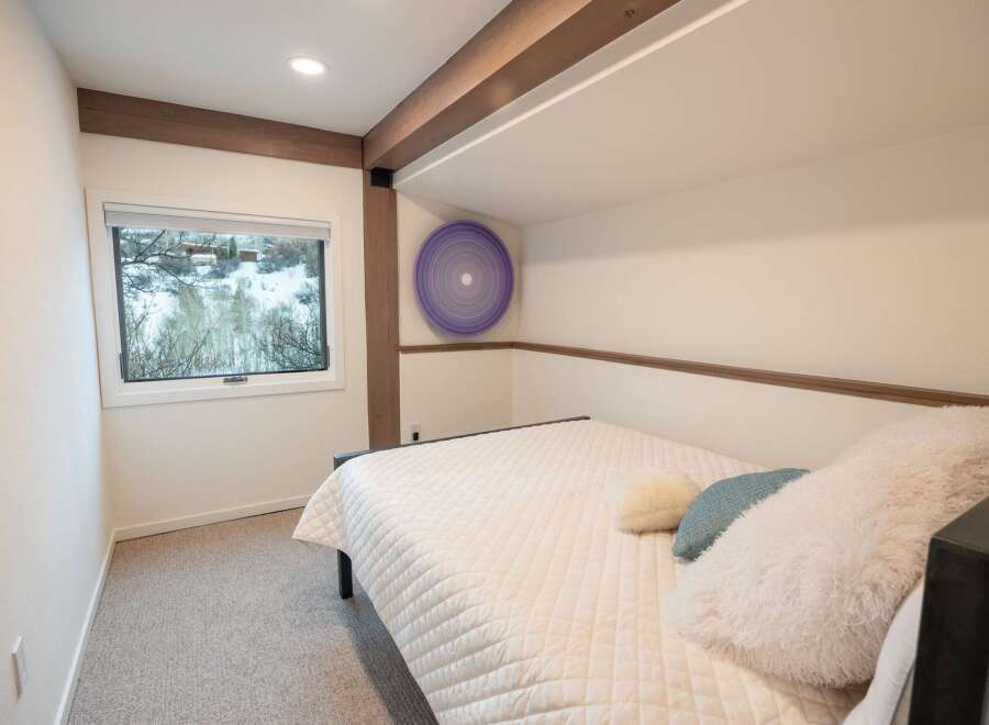 This cozy bedroom offers a serene retreat with its neutral color palette and inviting ambiance.