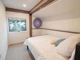 This cozy bedroom offers a serene retreat with its neutral color palette and inviting ambiance.