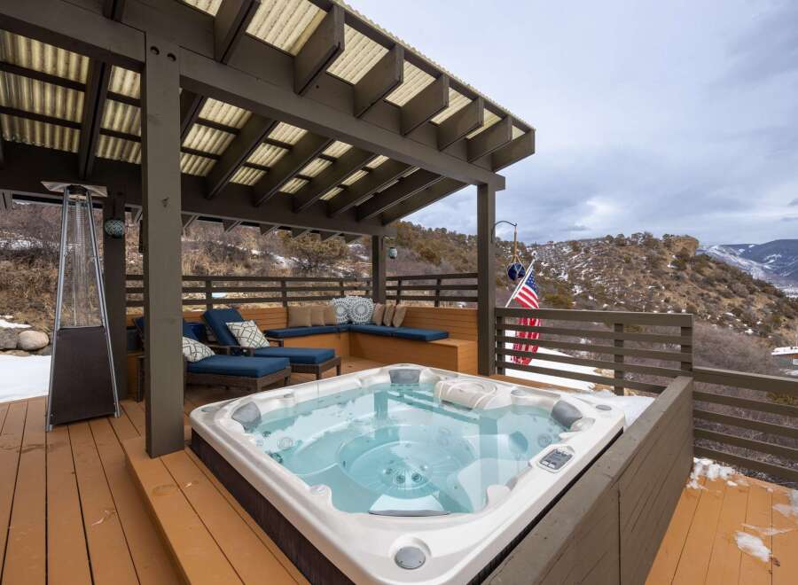 Relax and unwind in this stunning outdoor oasis featuring a luxurious hot tub, perfect for enjoying breathtaking mountain views.