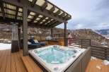 Relax and unwind in this stunning outdoor oasis featuring a luxurious hot tub, perfect for enjoying breathtaking mountain views.