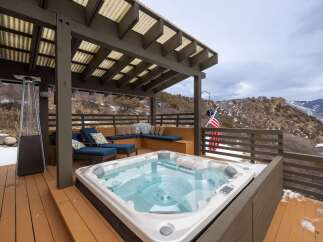 Relax and unwind in this stunning outdoor oasis featuring a luxurious hot tub, perfect for enjoying breathtaking mountain views.