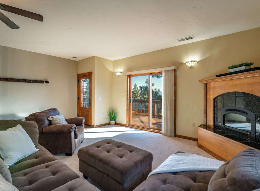 Step into a cozy living space with a beautiful fireplace and a sliding door that leads to a deck.