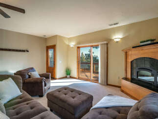 Step into a cozy living space with a beautiful fireplace and a sliding door that leads to a deck.