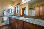 This stunning bathroom features a double vanity with a granite countertop, offering ample space and a touch of luxury.