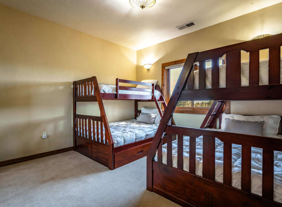 This cozy bedroom features two sets of bunk beds, perfect for accommodating multiple guests or family members.