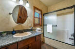 This charming bathroom features a rustic design with a wooden vanity and a granite countertop.