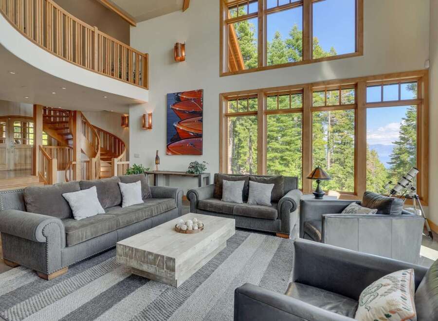 Experience luxury living in this stunning property, featuring a grand living room with soaring ceilings and expansive windows that frame breathtaking views.