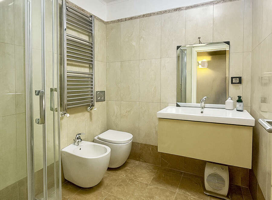 Step into this elegant bathroom featuring a modern shower, a stylish vanity, and a convenient bidet.