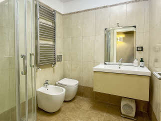 Step into this elegant bathroom featuring a modern shower, a stylish vanity, and a convenient bidet.