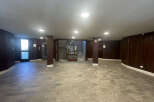 This spacious entryway boasts a unique design with dark wood paneling and a tiled floor, creating a warm and inviting atmosphere.