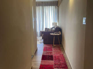 Step into luxury with this stunning property! The hallway features a vibrant red patchwork rug that adds a touch of warmth and character.