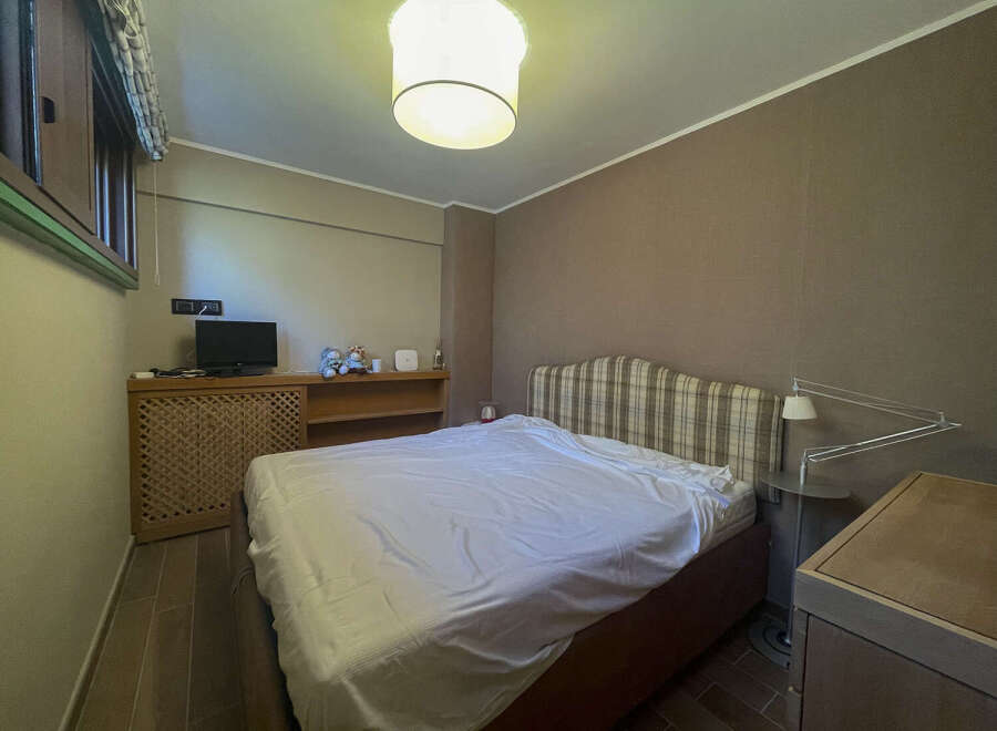 This cozy bedroom features a comfortable bed with a plaid headboard, perfect for a relaxing retreat.