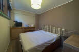 This cozy bedroom features a comfortable bed with a plaid headboard, perfect for a relaxing retreat.