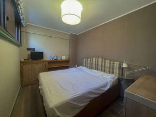 This cozy bedroom features a comfortable bed with a plaid headboard, perfect for a relaxing retreat.