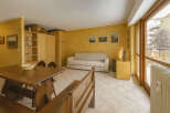 This charming property features a cozy living space with a comfortable sofa and a dining area with a wooden table.