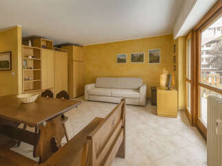 This charming property features a cozy living space with a comfortable sofa and a dining area with a wooden table.
