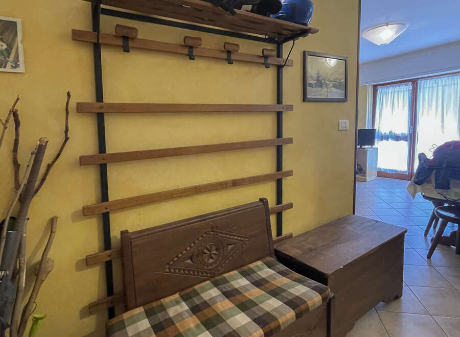 This charming entryway features a unique wooden bench with a patterned cushion, perfect for a cozy welcome.