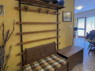 This charming entryway features a unique wooden bench with a patterned cushion, perfect for a cozy welcome.