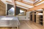 This cozy bedroom features a rustic wooden ceiling and walls, creating a warm and inviting atmosphere.