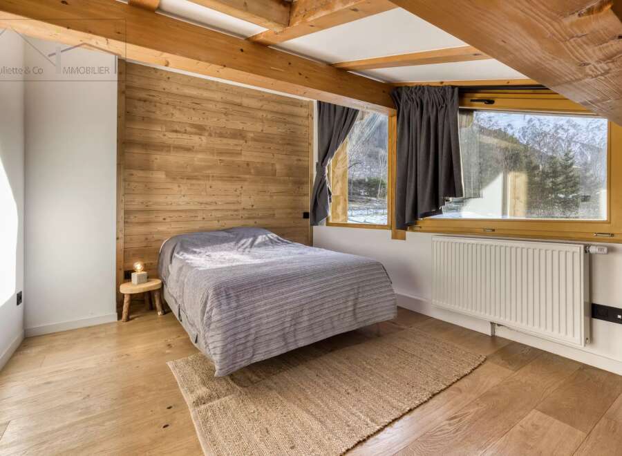 This cozy bedroom features a rustic wooden accent wall and exposed beams, creating a warm and inviting atmosphere.