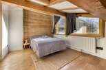 This cozy bedroom features a rustic wooden accent wall and exposed beams, creating a warm and inviting atmosphere.