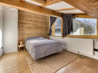 This cozy bedroom features a rustic wooden accent wall and exposed beams, creating a warm and inviting atmosphere.