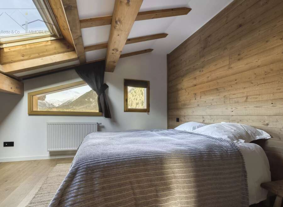 Experience the charm of this cozy bedroom featuring a rustic wooden headboard and exposed beams.