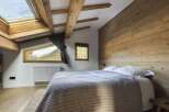 Experience the charm of this cozy bedroom featuring a rustic wooden headboard and exposed beams.