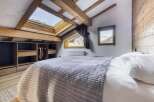This charming bedroom features a cozy, inviting atmosphere with its wooden beams and natural light.