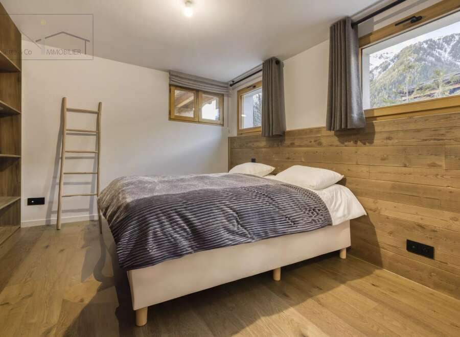 This cozy bedroom features a comfortable bed with a stylish gray blanket, perfect for a relaxing retreat.