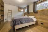 This cozy bedroom features a comfortable bed with a stylish gray blanket, perfect for a relaxing retreat.