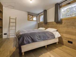 This cozy bedroom features a comfortable bed with a stylish gray blanket, perfect for a relaxing retreat.