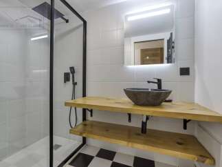 This modern bathroom features a sleek, minimalist design with a black and white checkered floor.
