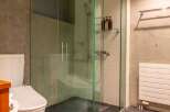 This modern bathroom features a sleek glass shower enclosure, offering a spa-like experience.
