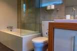 This modern bathroom features a sleek design with a soaking tub, glass shower enclosure, and a stylish vanity.
