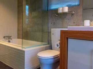 This modern bathroom features a sleek design with a soaking tub, glass shower enclosure, and a stylish vanity.