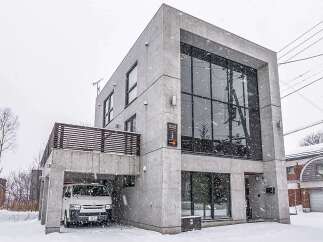 This modern architectural marvel showcases a stunning concrete facade and expansive windows, offering a contemporary living experience.