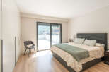 This stunning bedroom offers a serene retreat with its modern design and ample natural light.