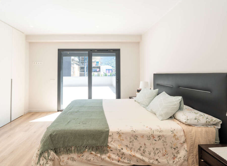 This modern bedroom boasts a sleek design with a comfortable bed and a stylish headboard.