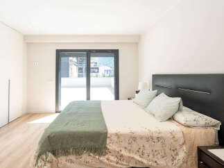 This modern bedroom boasts a sleek design with a comfortable bed and a stylish headboard.