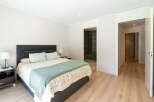 This inviting bedroom offers a serene retreat with its neutral color palette and ample natural light.