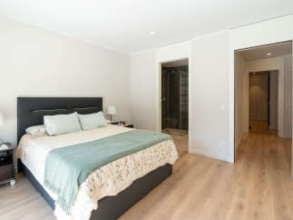 This inviting bedroom offers a serene retreat with its neutral color palette and ample natural light.