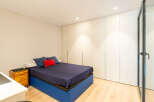 This modern bedroom boasts a sleek design with a comfortable bed and ample storage.