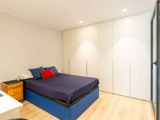 This modern bedroom boasts a sleek design with a comfortable bed and ample storage.