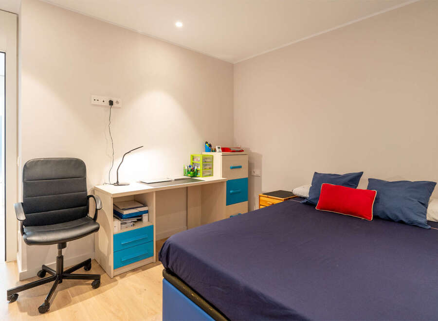 This cozy bedroom features a comfortable bed with a navy blue duvet and decorative pillows.