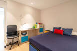 This cozy bedroom features a comfortable bed with a navy blue duvet and decorative pillows.