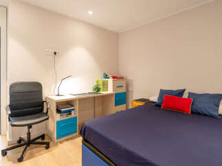 This cozy bedroom features a comfortable bed with a navy blue duvet and decorative pillows.