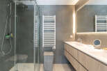 Step into a modern bathroom oasis! This stunning space features a sleek glass shower, a stylish vanity with ample storage, and a heated towel rack for added comfort.